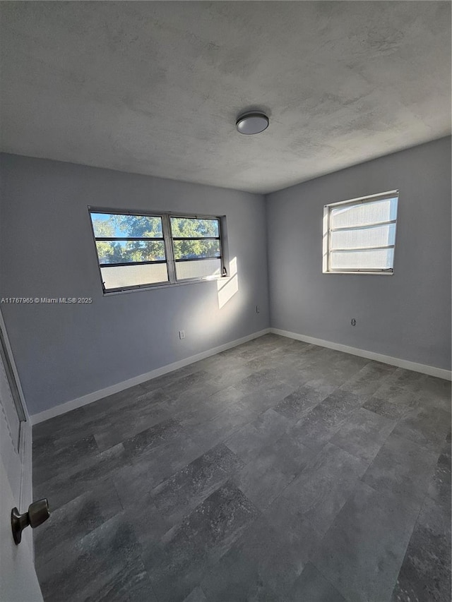 spare room with baseboards