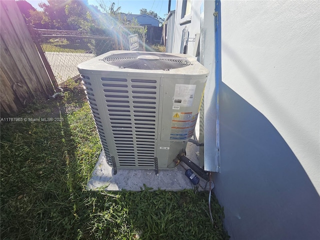 exterior details featuring central AC unit, fence, and stucco siding