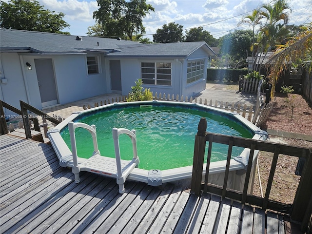 pool featuring a wooden deck and fence