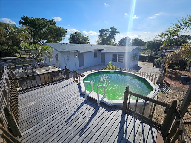 pool featuring fence and a wooden deck