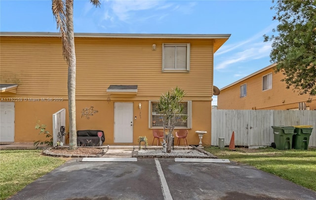 265 NE 12th Ave Unit 265, Homestead, FL 33030 - view of front of property with fence, uncovered parking, a front lawn, and stucco siding