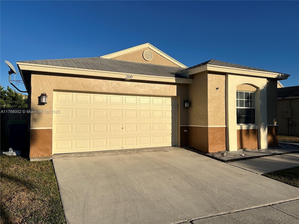 single story home with stucco siding, driveway, and a garage