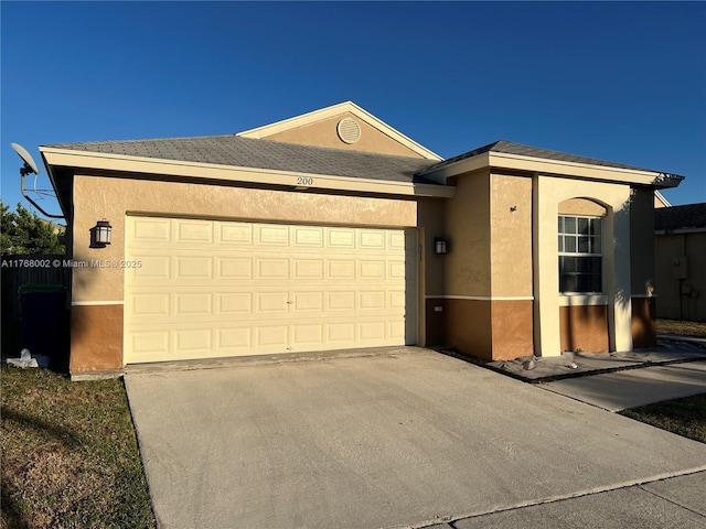 single story home with stucco siding, driveway, and a garage