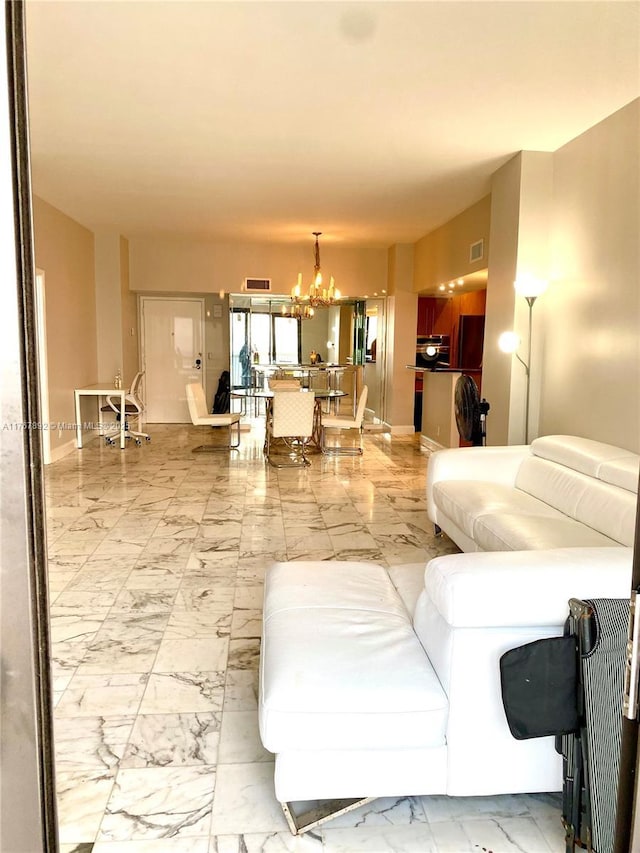 living area featuring a notable chandelier, marble finish floor, baseboards, and visible vents