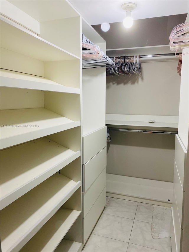 spacious closet with light tile patterned floors