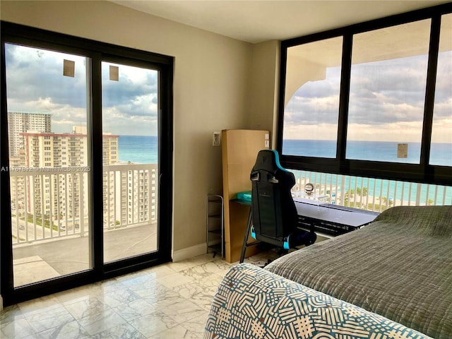 bedroom featuring access to exterior, multiple windows, baseboards, and a water view
