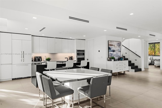 2572 NE 182nd Ter, North Miami Beach, FL 33160 - dining room with light tile patterned floors, visible vents, recessed lighting, and stairway