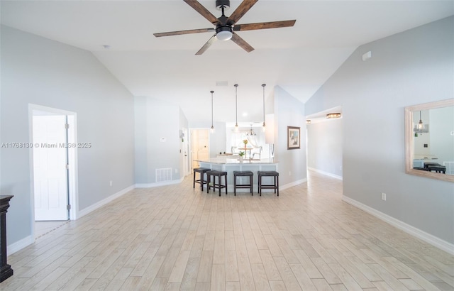 3705 NE 15th Ave, Cape Coral, FL 33909 - unfurnished living room with visible vents, baseboards, ceiling fan, light wood-style flooring, and high vaulted ceiling