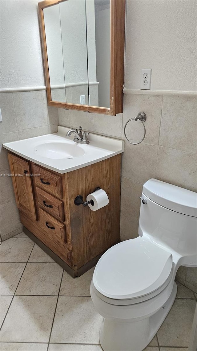 13715 Kendale Lakes Cir Unit A-201, Miami, FL 33183 - half bath featuring tile walls, toilet, vanity, a textured wall, and wainscoting