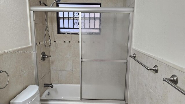 13715 Kendale Lakes Cir Unit A-201, Miami, FL 33183 - full bath featuring toilet, enclosed tub / shower combo, wainscoting, and tile walls