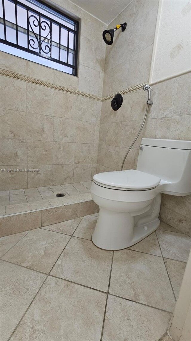 13715 Kendale Lakes Cir Unit A-201, Miami, FL 33183 - full bathroom featuring toilet, tiled shower, and tile walls
