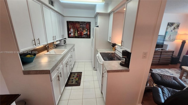 2112 Newport U Unit 2112, Deerfield Beach, FL 33442 - kitchen with visible vents, light tile patterned flooring, white cabinets, white appliances, and a sink