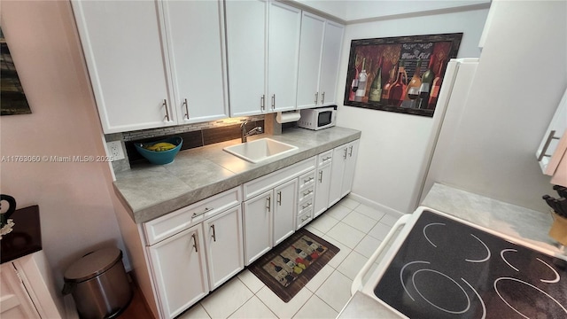 2112 Newport U Unit 2112, Deerfield Beach, FL 33442 - kitchen with tasteful backsplash, light tile patterned floors, white cabinets, white appliances, and a sink