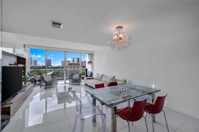 dining room featuring a city view, light tile patterned flooring, visible vents, and a chandelier