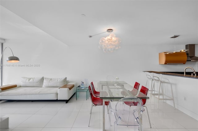 tiled dining space with a chandelier and a sink