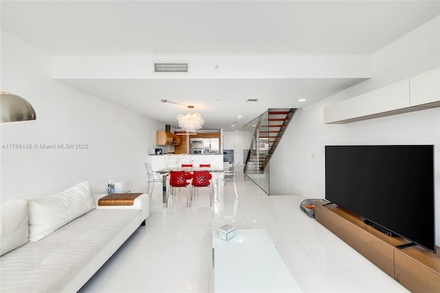 living room featuring recessed lighting, visible vents, light tile patterned flooring, and stairway