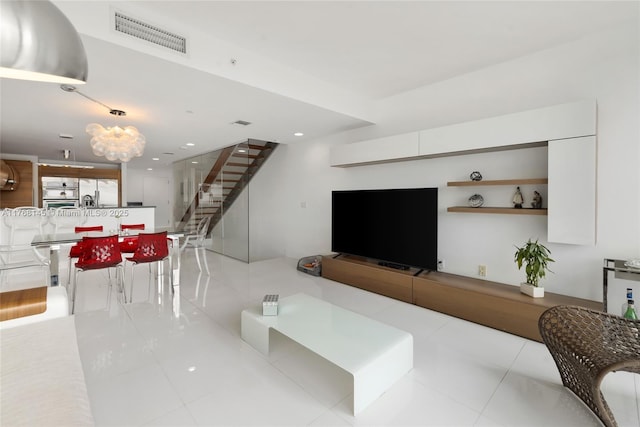 living room with tile patterned floors, visible vents, recessed lighting, and stairway