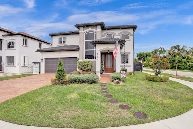 mediterranean / spanish home featuring a garage, stucco siding, driveway, and a tiled roof