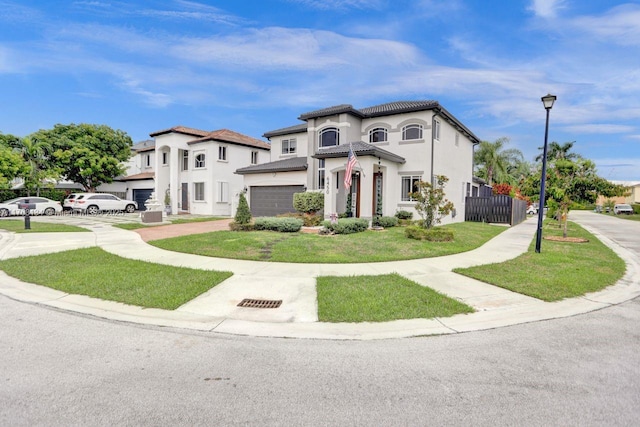 mediterranean / spanish-style home with stucco siding, a front lawn, fence, an attached garage, and a tiled roof
