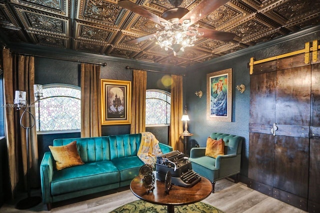 living area with wood finished floors, an ornate ceiling, ornamental molding, ceiling fan, and a textured wall