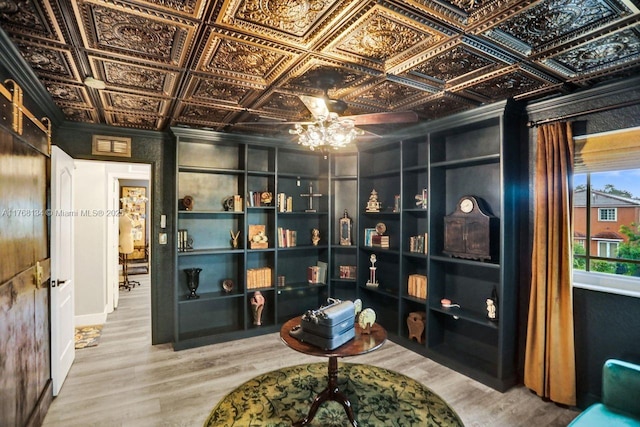 sitting room featuring wood finished floors, visible vents, an ornate ceiling, ornamental molding, and ceiling fan