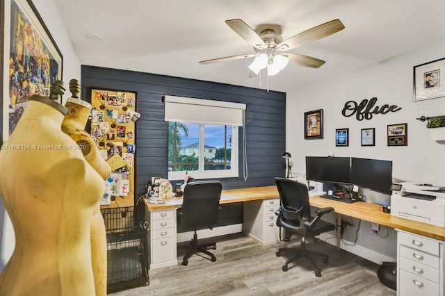 office area with baseboards, light wood-style flooring, and a ceiling fan