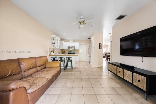 living area with light tile patterned floors, visible vents, recessed lighting, and ceiling fan