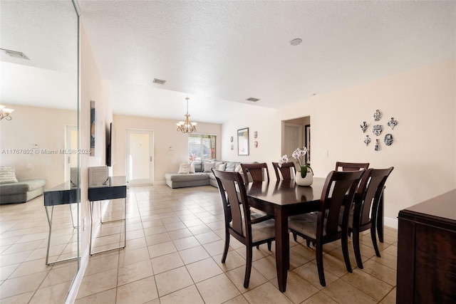 dining room featuring a notable chandelier, light tile patterned flooring, visible vents, and a textured ceiling