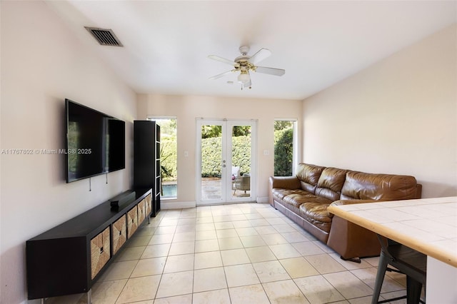 living room with visible vents, light tile patterned flooring, a ceiling fan, and french doors