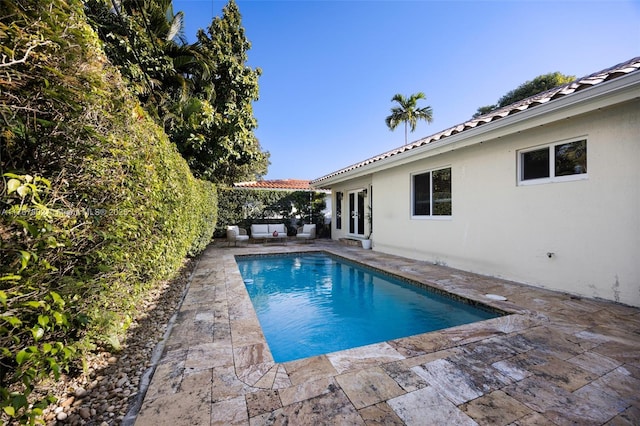 pool with french doors and a patio