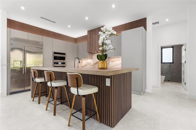2523 Red Rd, Coral Gables, FL 33134 - kitchen featuring stainless steel appliances, a kitchen breakfast bar, recessed lighting, an island with sink, and modern cabinets