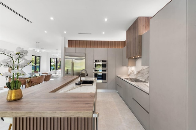 2523 Red Rd, Coral Gables, FL 33134 - kitchen featuring a sink, stainless steel appliances, modern cabinets, light countertops, and gray cabinetry