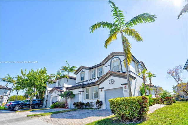 7807 NW 114th Pl, Doral, FL 33178 - view of property featuring stucco siding, a tile roof, decorative driveway, and a garage