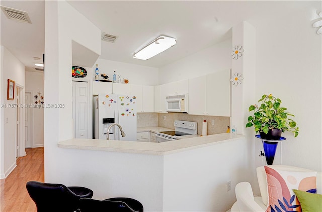 7807 NW 114th Pl, Doral, FL 33178 - kitchen featuring visible vents, white appliances, tasteful backsplash, and light countertops
