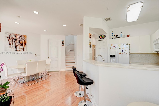 7807 NW 114th Pl, Doral, FL 33178 - kitchen with visible vents, white appliances, light wood-style floors, and light countertops