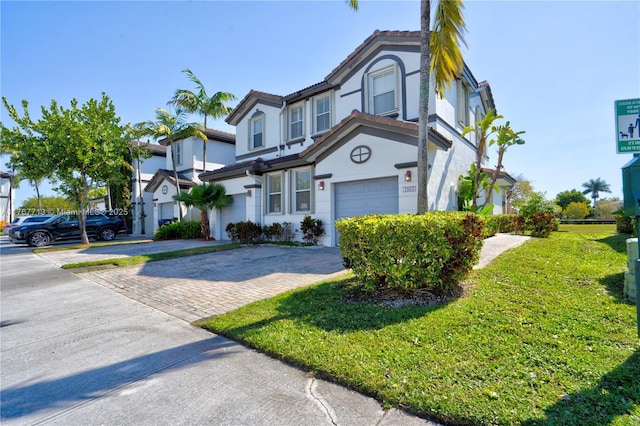 7807 NW 114th Pl, Doral, FL 33178 - townhome / multi-family property with stucco siding, decorative driveway, a front yard, a garage, and a tiled roof