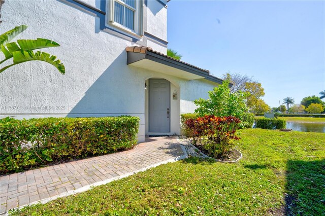 7807 NW 114th Pl, Doral, FL 33178 - entrance to property with a yard, a water view, and stucco siding