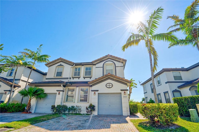 7807 NW 114th Pl, Doral, FL 33178 - view of front of home featuring a tiled roof, stucco siding, an attached garage, and decorative driveway