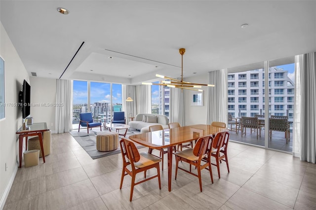 dining area featuring visible vents, a city view, floor to ceiling windows, light tile patterned floors, and a chandelier