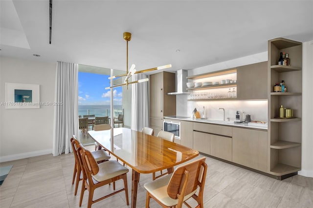 dining area with a wall of windows, an inviting chandelier, baseboards, and indoor wet bar