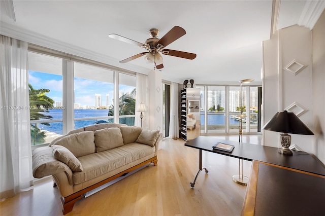 living room featuring a ceiling fan, wood finished floors, and floor to ceiling windows