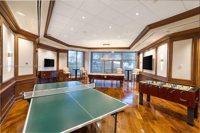 recreation room with a decorative wall, pool table, crown molding, and wood-type flooring