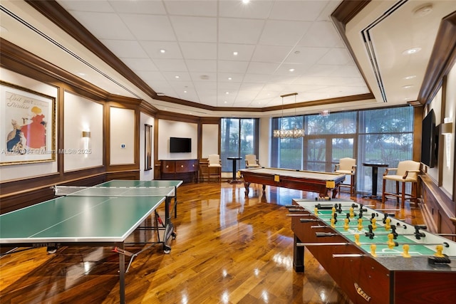 rec room featuring billiards, a decorative wall, wood finished floors, and ornamental molding