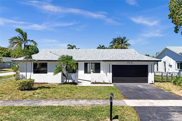 ranch-style house with a garage, a front yard, brick siding, and driveway