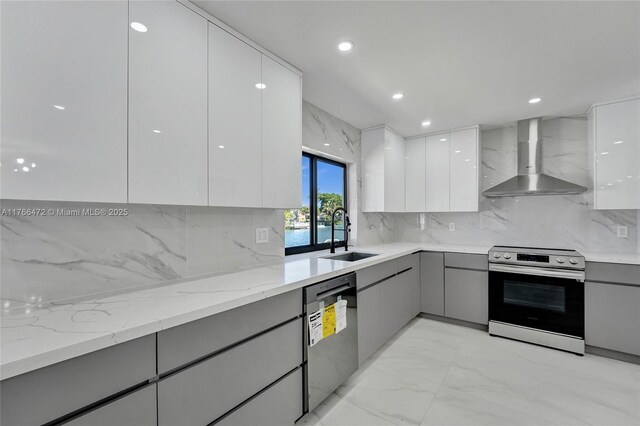 kitchen with stainless steel appliances, modern cabinets, wall chimney exhaust hood, and gray cabinets