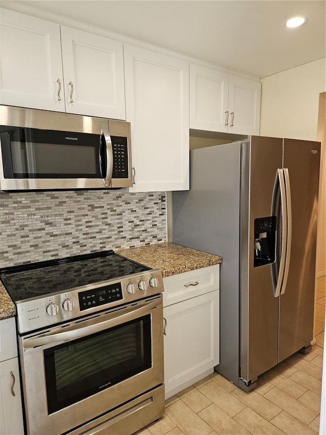 250 Layne Blvd Unit 105, Hallandale Beach, FL 33009 - kitchen with dark stone counters, white cabinets, decorative backsplash, and stainless steel appliances