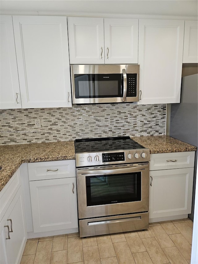 250 Layne Blvd Unit 105, Hallandale Beach, FL 33009 - kitchen featuring white cabinetry, stainless steel appliances, dark stone countertops, and decorative backsplash