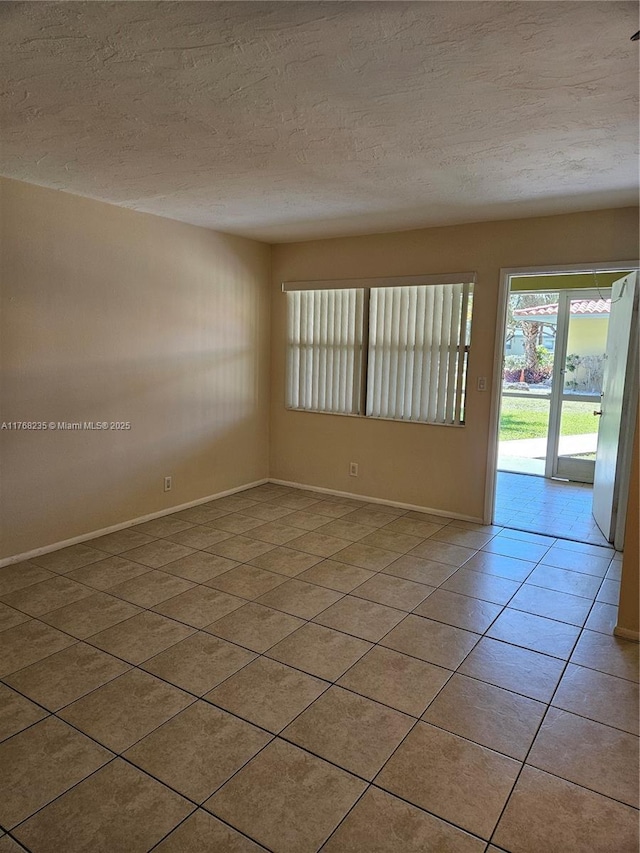 250 Layne Blvd Unit 105, Hallandale Beach, FL 33009 - spare room with light tile patterned flooring, a textured ceiling, and baseboards