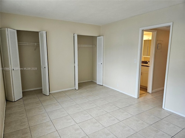 250 Layne Blvd Unit 105, Hallandale Beach, FL 33009 - unfurnished bedroom with light tile patterned flooring, baseboards, and multiple closets