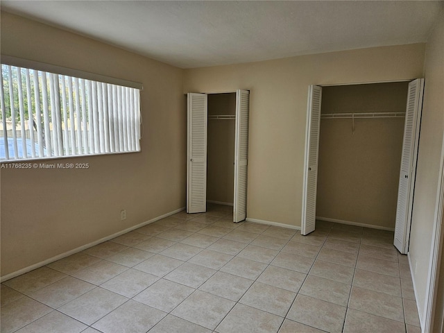 250 Layne Blvd Unit 105, Hallandale Beach, FL 33009 - unfurnished bedroom with baseboards, multiple closets, and light tile patterned floors
